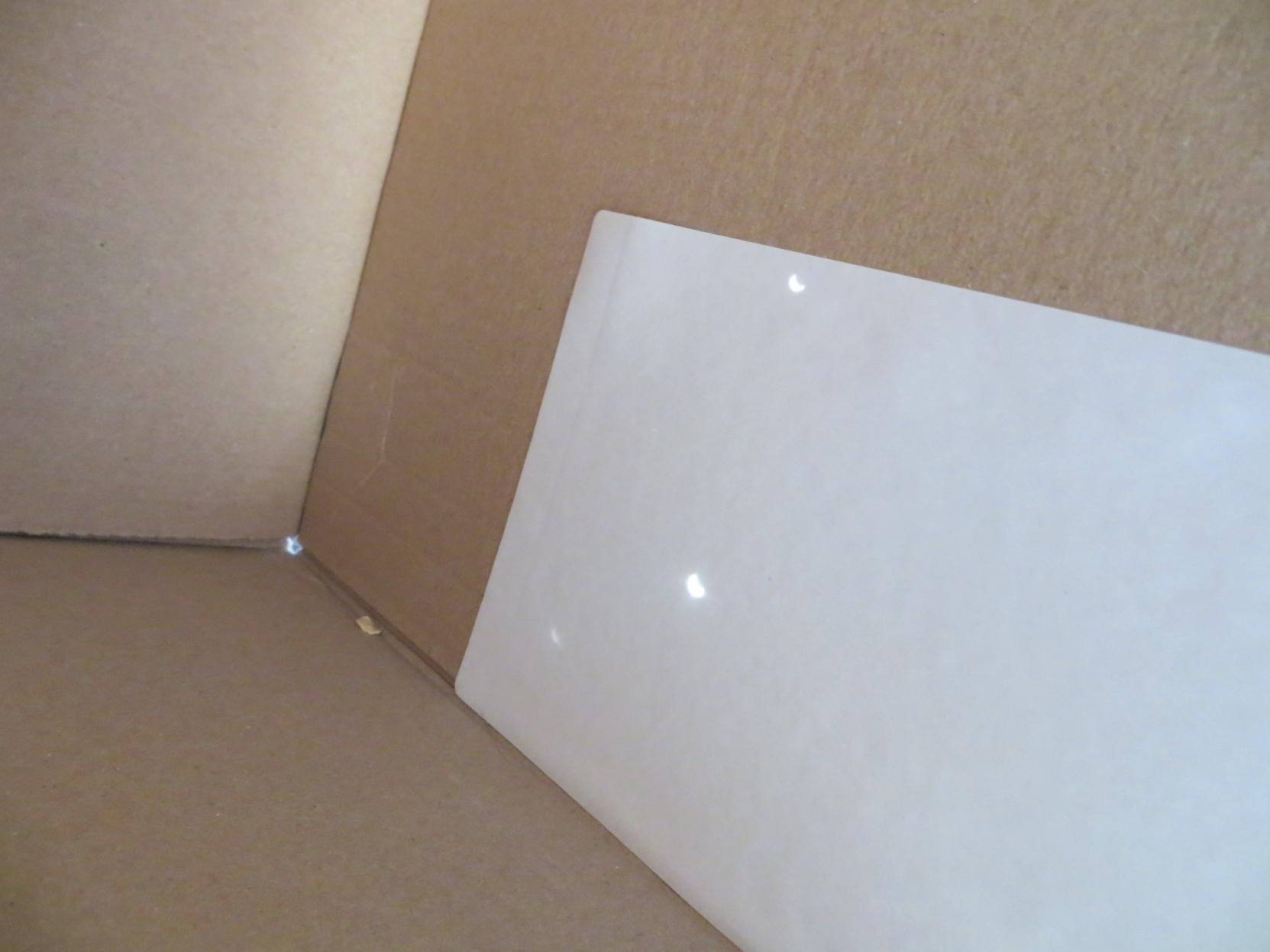 Camera obscura, with two bright spots on the white area where the eclipse is visible (through two differently sized holes).
